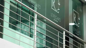 Fachada de edificio con múltiples ventanas que muestra el logo 'Le Régard Hotel Boutique'.