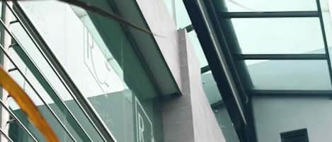 Un edificio moderno con fachada de vidrio y barandillas de metal.