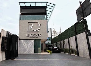 Un moderno edificio de hotel con un logotipo destacado y el nombre 'LE REGARD HOTEL BOUTIQUE'.