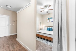 A bedroom with a bed, a ceiling fan, and a nightstand.