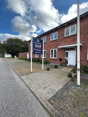 A brick building with a signboard indicating a B&B.