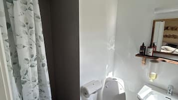 Un baño moderno con inodoro, lavamanos y cortina de ducha.