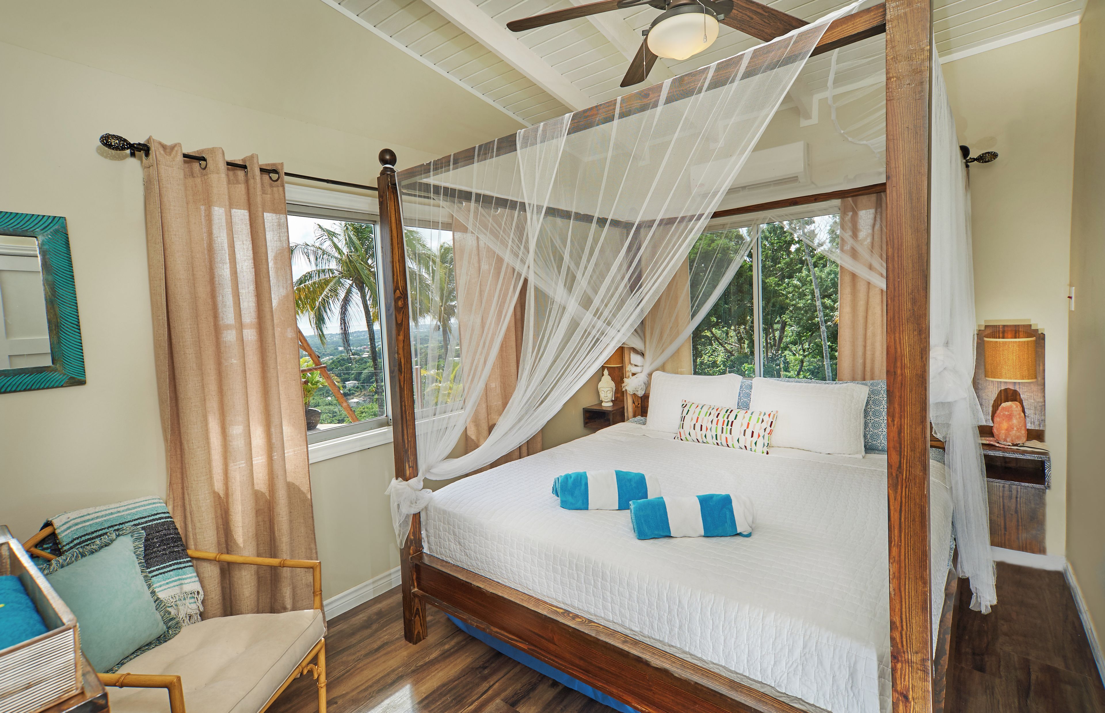A four-poster bed with a canopy, a wooden chair, and a nightstand with a lamp.