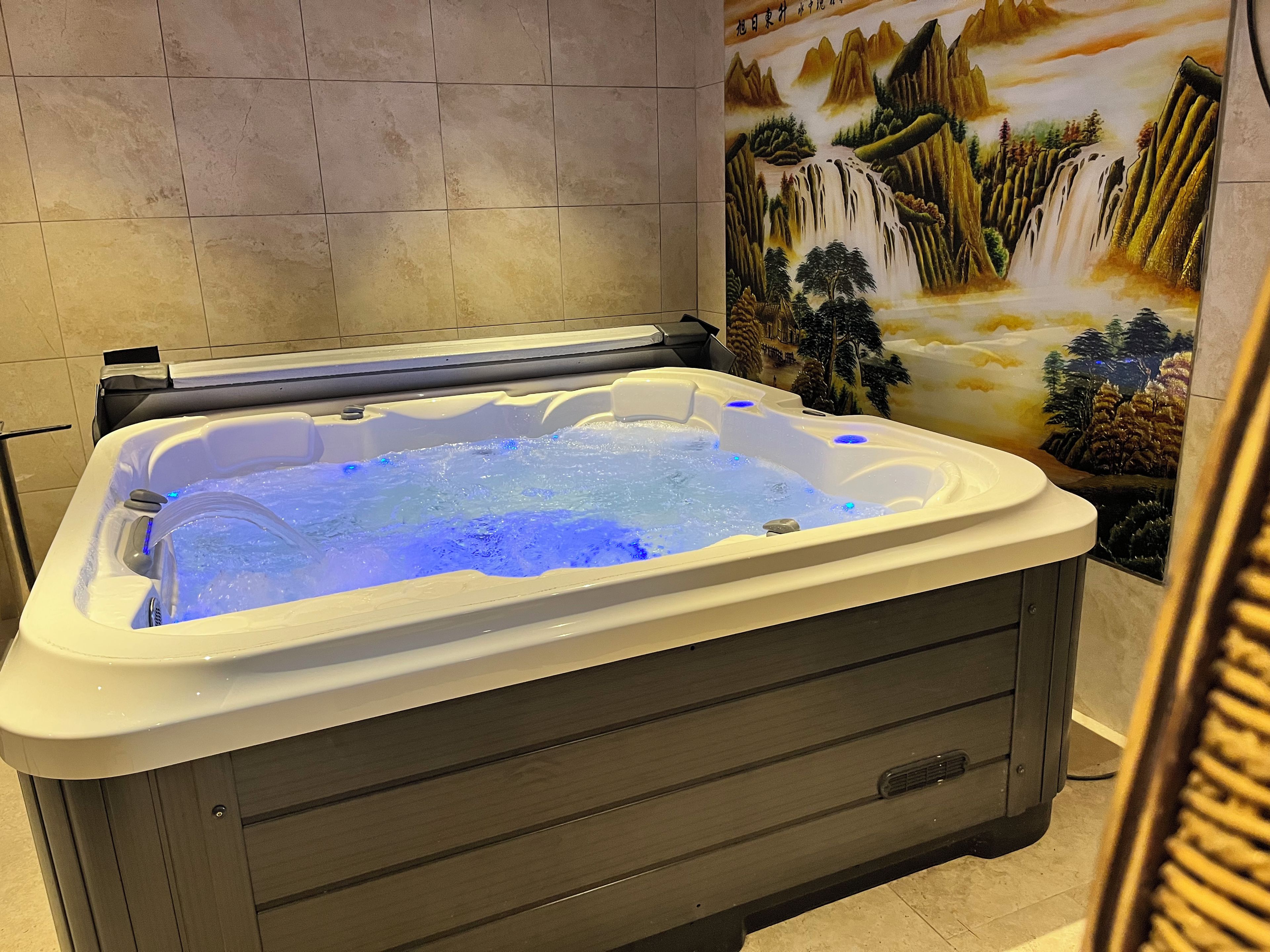 Een jacuzzi met een wanddecoratie van een waterval.