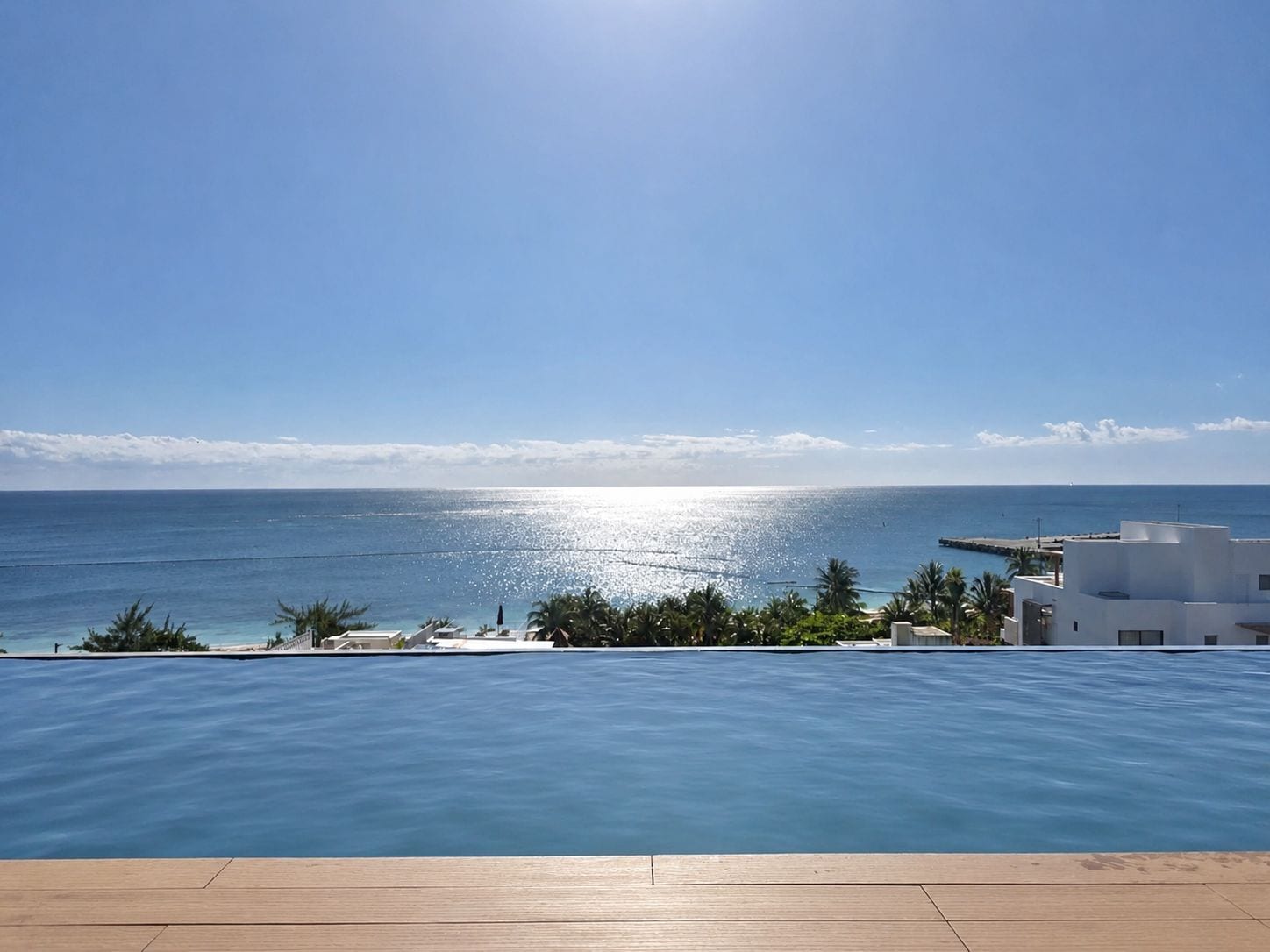 Ein Schwimmbecken mit Blick auf den Ozean und einen klaren Himmel.