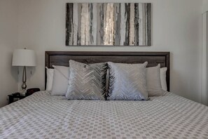 A neatly made bed with patterned bedding, a wooden headboard, and a wall-mounted abstract painting. - Meticulous & Upscale, Sleeps 10, Private Hot Tub - Perfect Location (Washington)