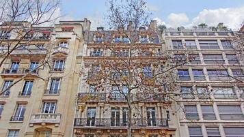 Um edifício com vários andares, varandas e janelas grandes.