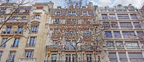 Un edificio de varios pisos con balcones y ventanas amplias.
