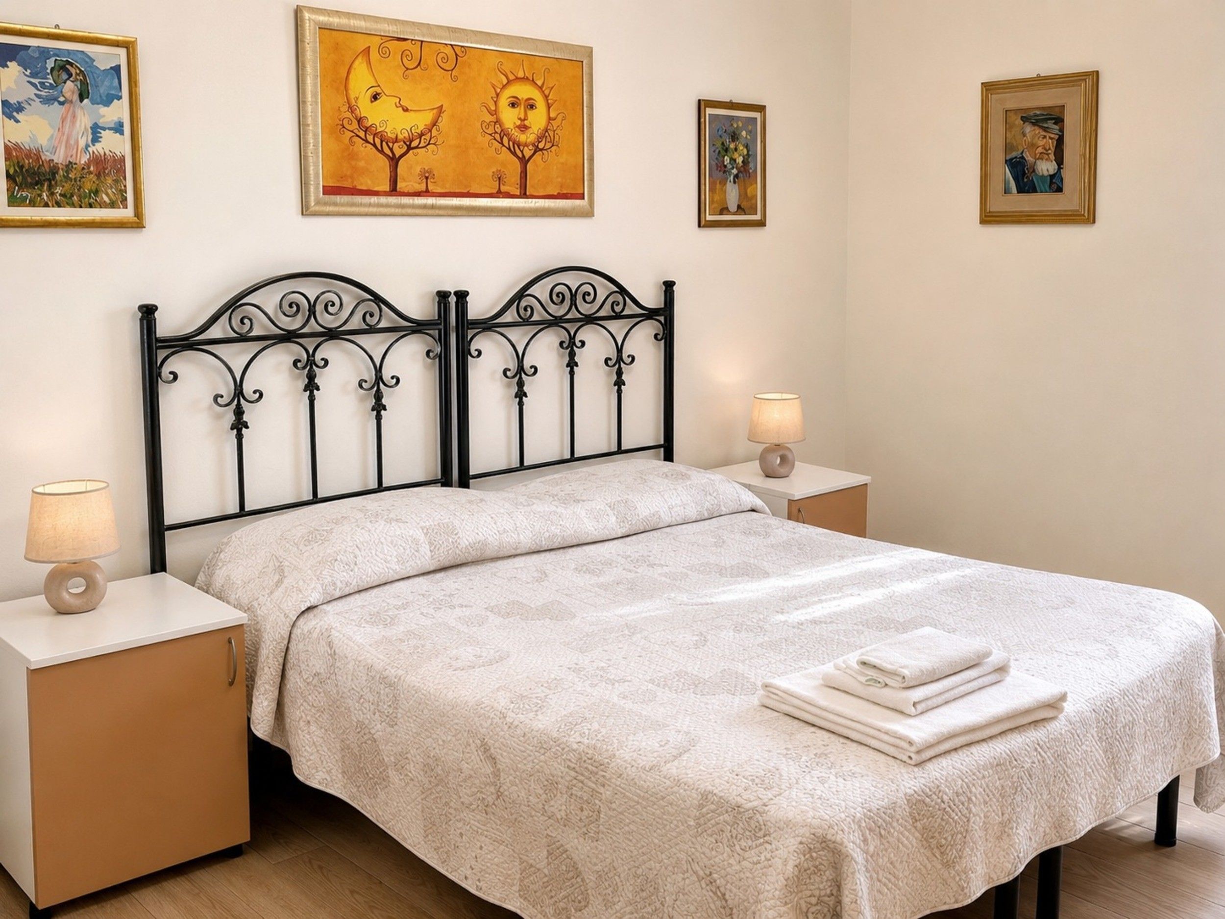 Ein Schlafzimmer mit Himmelbett, zwei Nachttischen und Bildern an den Wänden.