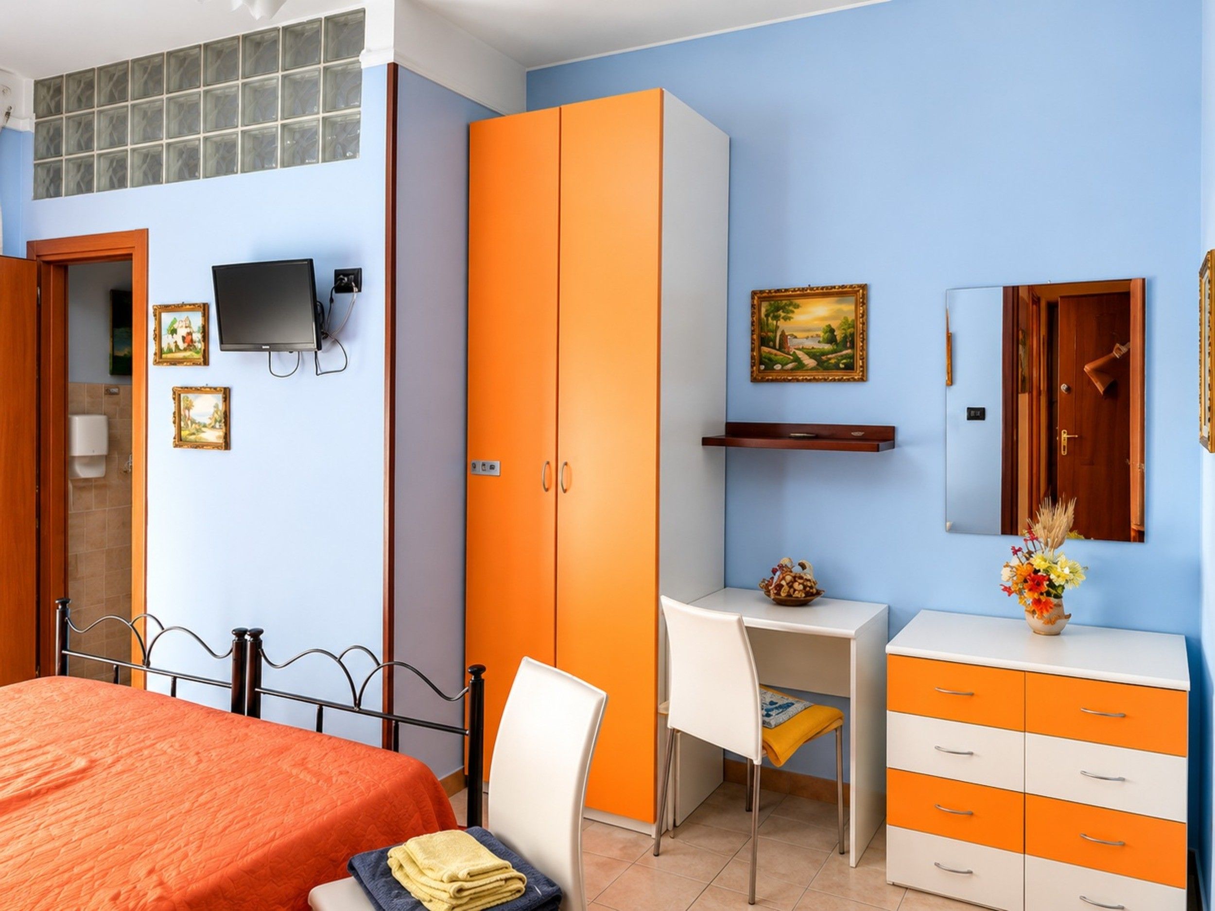 Une chambre à coucher avec un lit, un bureau et une armoire.