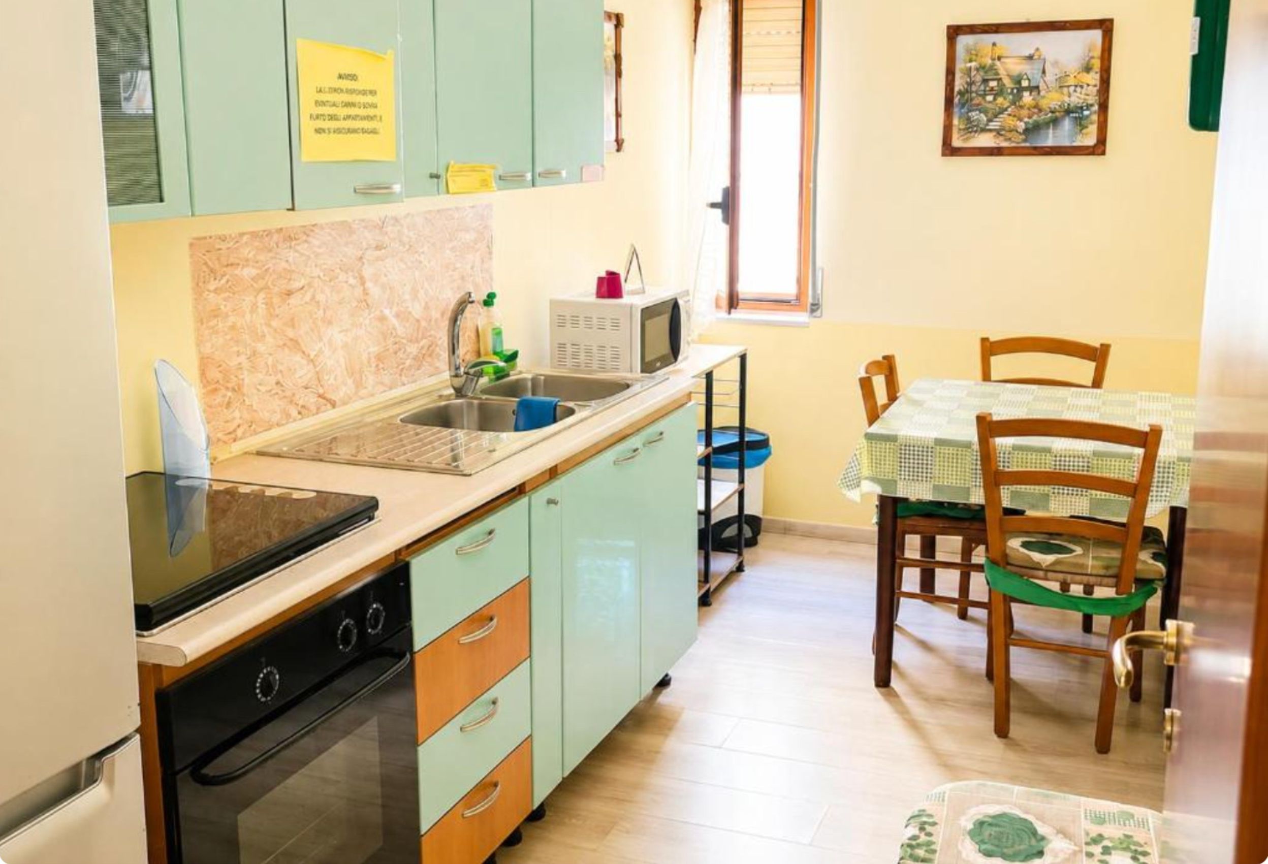 Une cuisine compacte équipée d’une cuisinière, d’un évier et d’un coin repas avec une table et des chaises.
