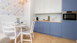Eine moderne Küche mit weißen und blauen Schränken, einer Holzarbeitsplatte und einem eingebauten Backofen.
