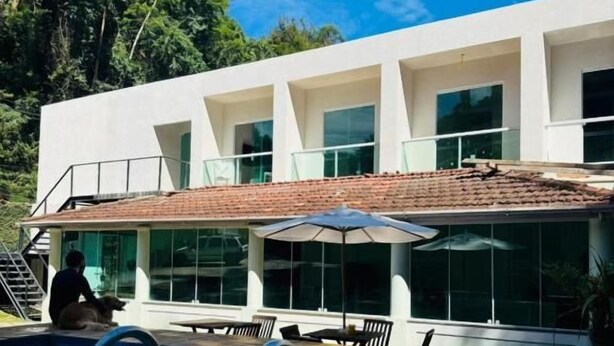 A modern house with a swimming pool, outdoor seating, and a covered patio. - Pousada M&M (Petrópolis)