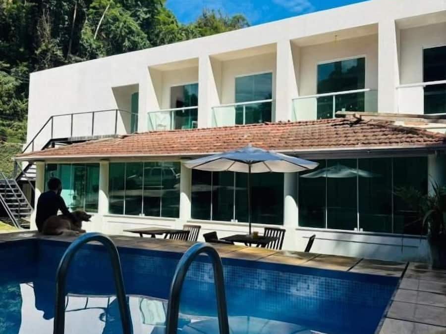 A modern house with a swimming pool, outdoor seating, and a covered patio.