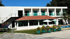 A modern building with a flat roof, multiple windows, and a staircase leading to an entrance. - Pousada M&M (Petrópolis)