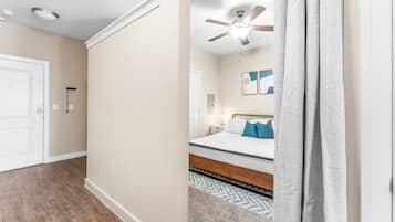A bedroom with a bed, a ceiling fan, and a nightstand.