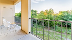 A balcony with a view of a green landscape and trees. - Spacious 2BR King Beds Suite 8 Min to Downtown (Austin)