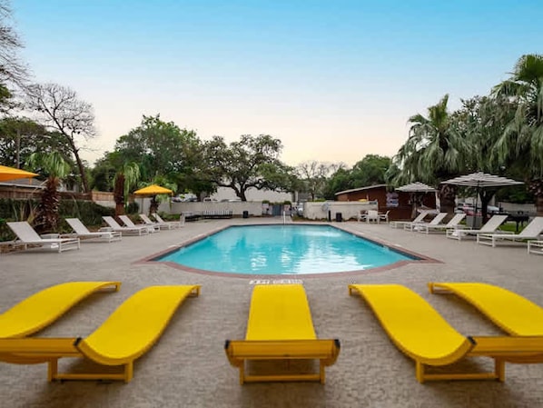 A swimming pool with sun loungers and umbrellas. - Soco Chic 1BR w Pool King bed Close to DT (Austin)