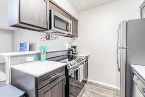 A modern kitchen with a built-in microwave, stove, and refrigerator. - Trendy Soco 1BR Suite King bed Fast Wifi w Pool (Austin)