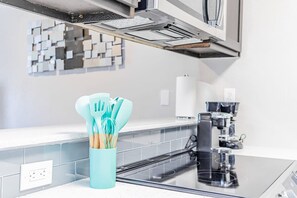 A kitchen with a modern stove, a coffee maker, and a utensil holder on the counter. - Trendy Soco 1BR Suite King bed Fast Wifi w Pool (Austin)