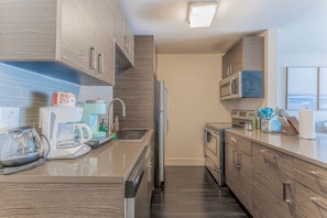 A modern kitchen with a built-in oven, microwave, and coffee maker. - Spacious 1BR Close to Downtown w Fast Wifi w Pool (Austin)