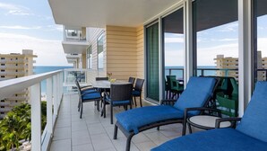 A balcony with a dining table, chairs, and a sofa. - Marriott Crystal Shores Resort - Poolside Luxurious 2BR Condo (Marco Island)