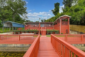 A two-story building with a covered porch and a red deck leading to the entrance.