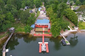 Une propriété au bord du lac, dotée d’un quai, d’un bâtiment rouge et entourée de verdure.