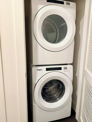 A stacked washer and dryer unit in a laundry room. - The Westside Retreat 2BD|2BTH (Atlanta)