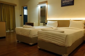 A hotel room with two beds, a bedside table, a mirror, and a window with curtains. - Kristal Grand (Bengaluru)