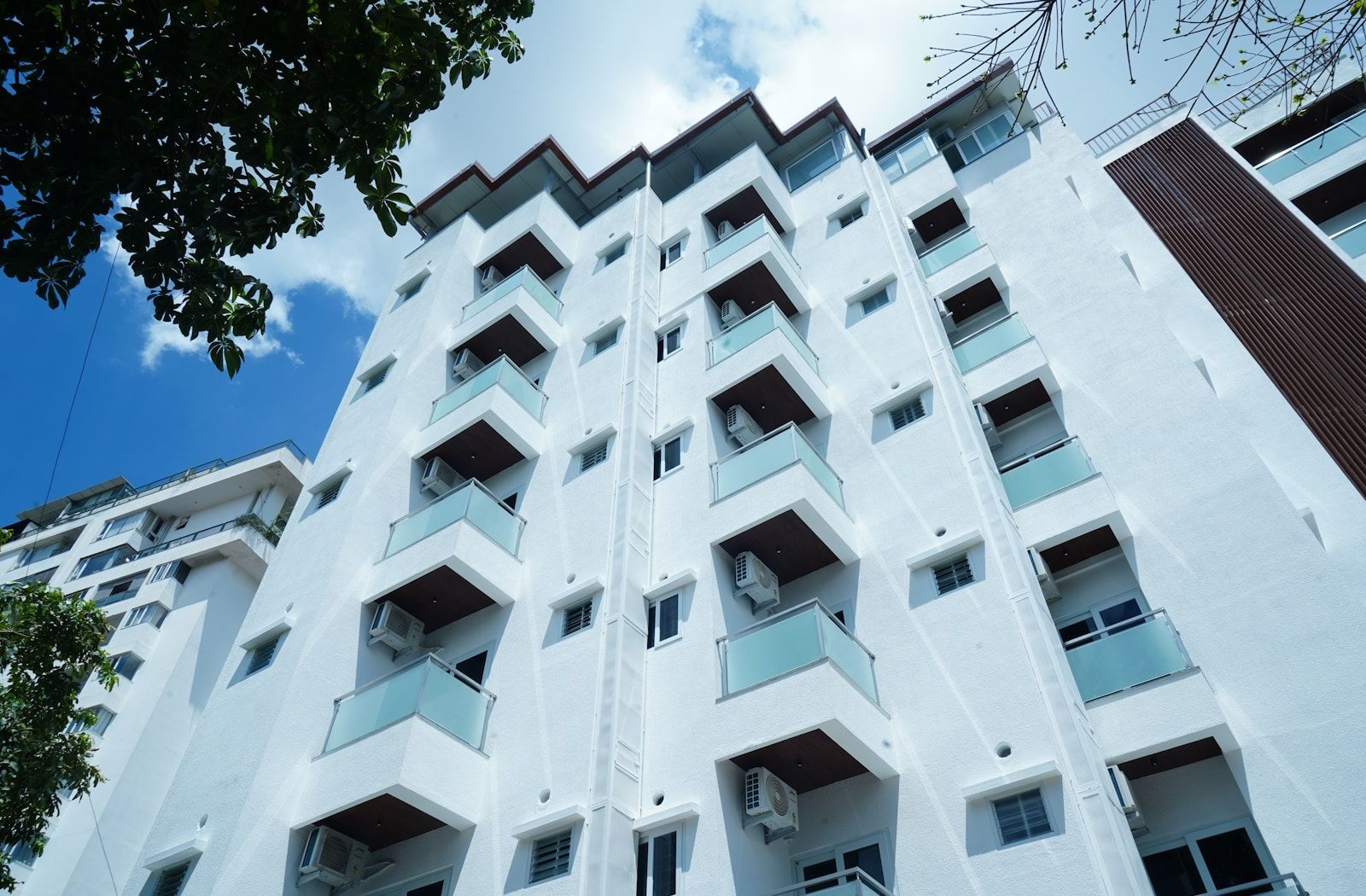 A multi-story building with balconies and air conditioning units.