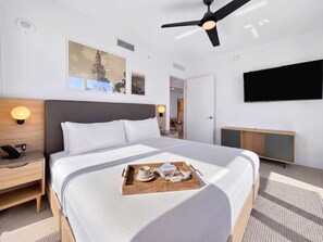 A modern hotel room with a large bed, bedside tables, a flat-screen TV, and artwork on the walls. - 31st Floor Luxury 2BR with Balcony & Pool (Miami)
