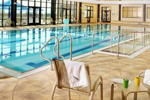 An indoor swimming pool with clear water, surrounded by lounge chairs and a tiled floor. - Fairway Stay: Golf Views, Pool & Near Eagle Ridge (Galena)