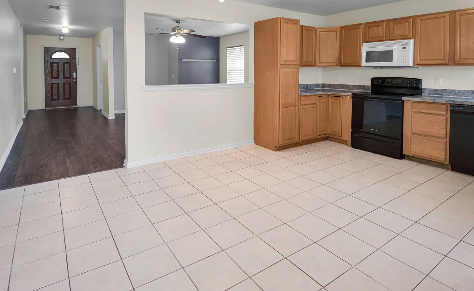 A kitchen with wooden cabinets, a microwave, a stove, and a dishwasher.