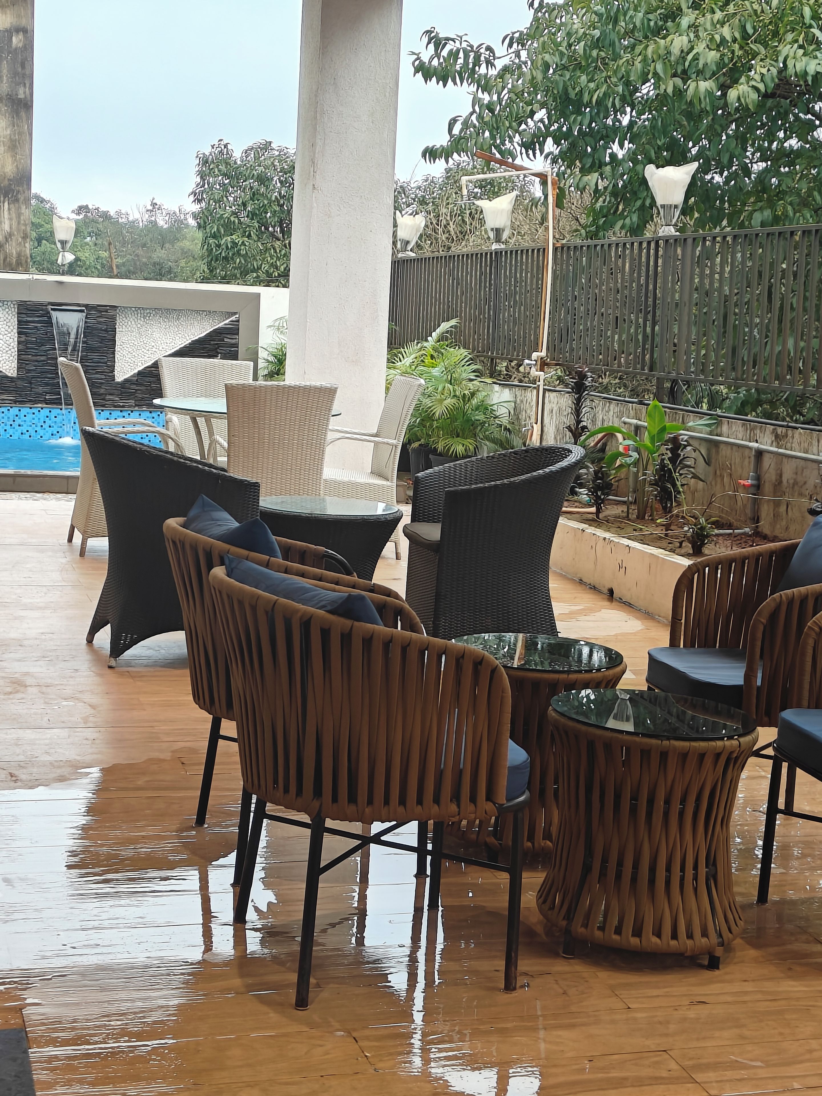 An outdoor seating area with wicker furniture and a pool.