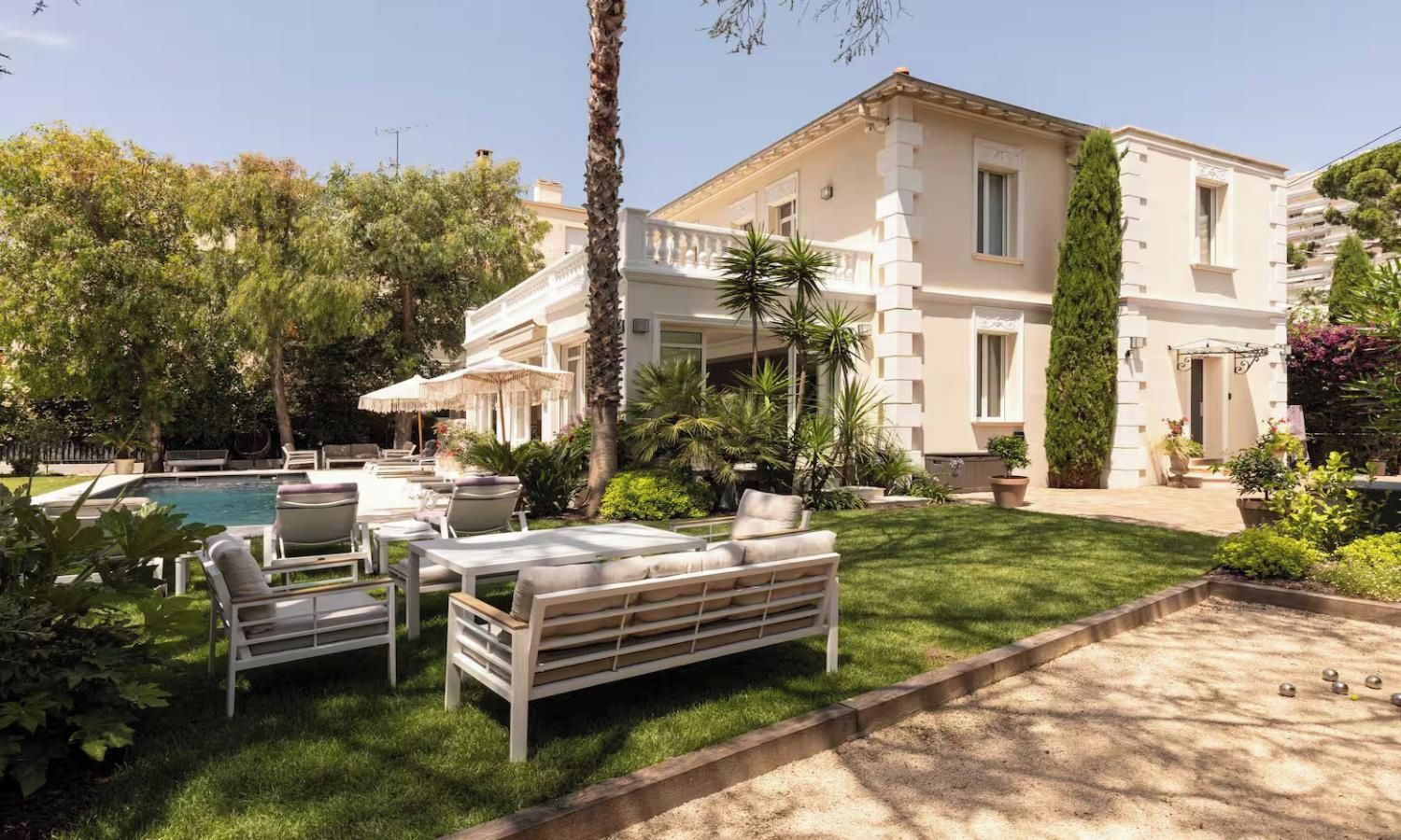 A poolside area with outdoor seating and a large building in the background.
