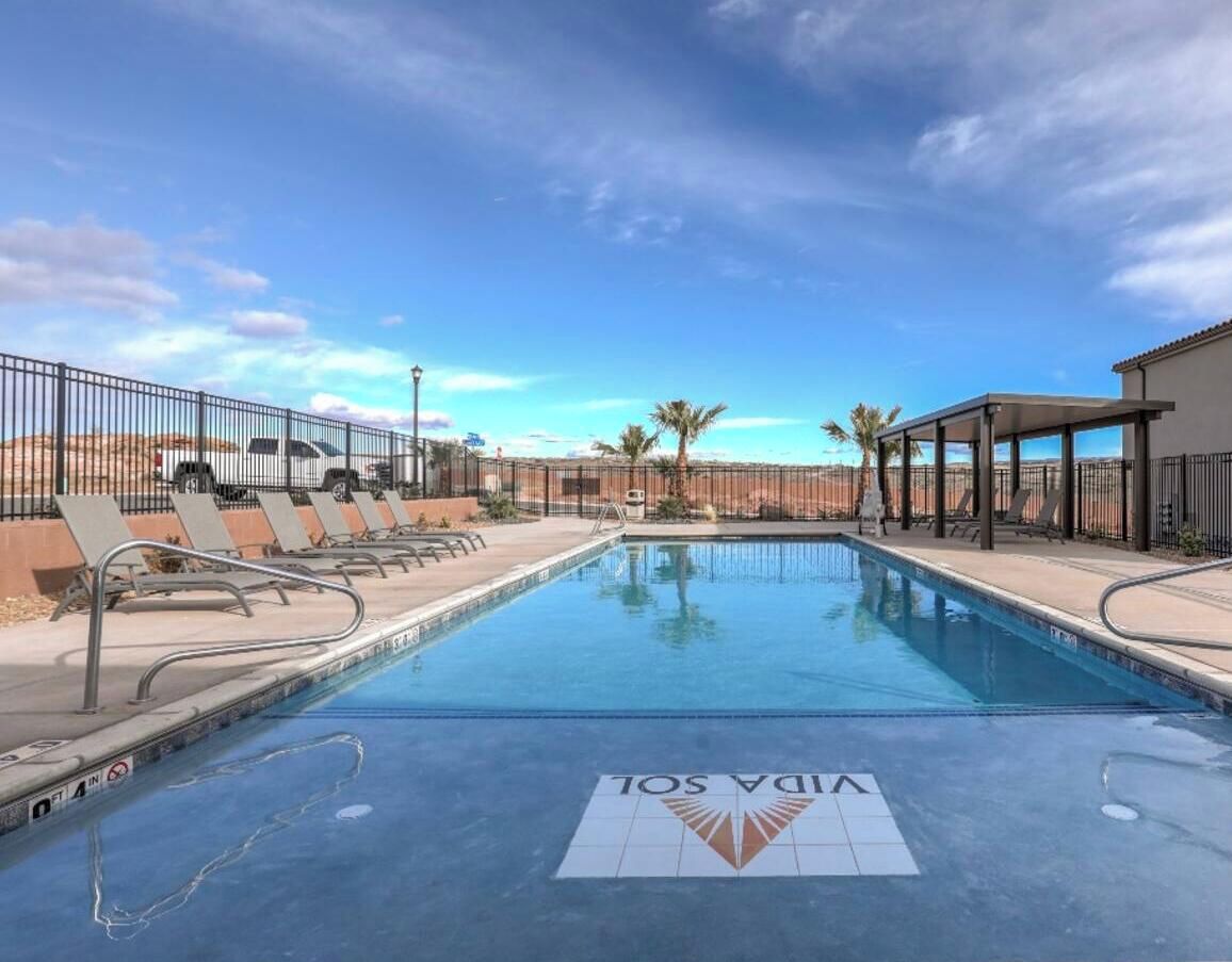 A swimming pool with lounge chairs and a desert landscape in the background.
