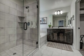 Une salle de bain moderne avec une douche à parois de verre, un meuble-lavabo en bois et un grand miroir au-dessus du lavabo.