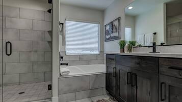 Indulge in the master en-suite bathroom featuring a luxurious soaking tub and spacious walk-in shower.