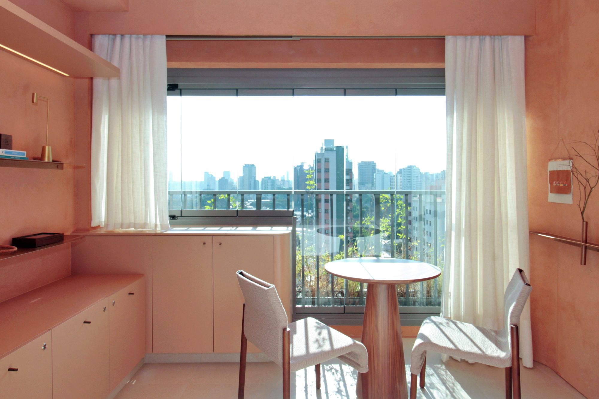 A modern room with a balcony, a round table, and two chairs.