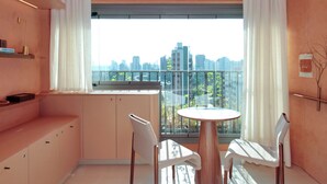 Una habitación moderna con balcón, una mesa redonda y dos sillas.