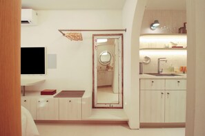 Casa de banho moderna com chuveiro, sanita e lavatório.