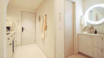 Un baño moderno con tocador, espejo y perchero.