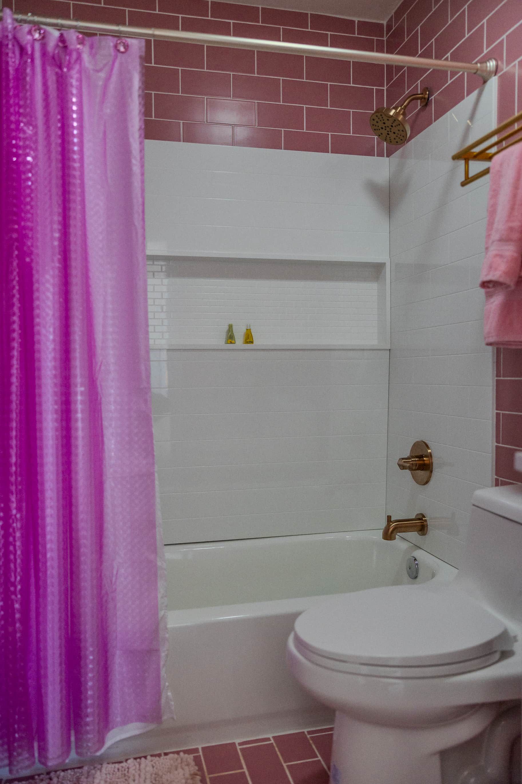 Een badkamer met een douche, toilet en een handdoekhouder.