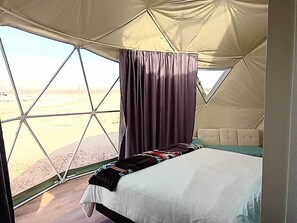 A tent with a bed and a window.
