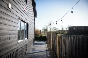 A wooden house with a narrow pathway leading to a gate. - Secret Water is a large house with wood-burning hot tub set on a small holding. (haverfordwest)