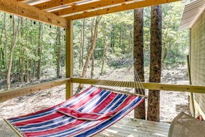 A hammock under a wooden deck with a view of a forest. - Boudreaux Run Cabin Ouachita National Forrest (Langley)