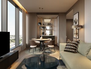 A modern living room with a glass coffee table, a sofa with patterned cushions, a dining area with chairs and a table, and a television on a stand. - InterContinental Belgrade by IHG (New Belgrade)