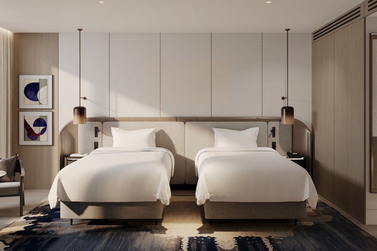 Una habitación de hotel moderna con dos camas, un ventanal grande y un diseño minimalista.