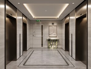 A modern elevator lobby with a marble floor, a wall-mounted digital display, and a minimalist design. - InterContinental Belgrade by IHG (New Belgrade)